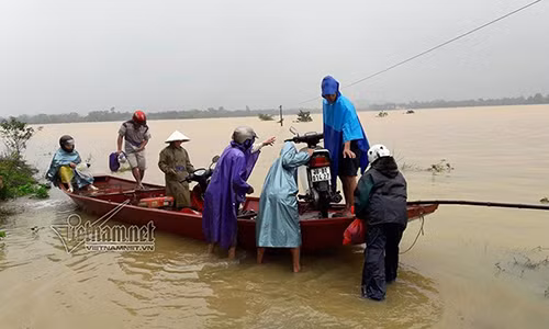 Phó Chủ tịch xã Lộc Yên (huyện Hương Khê) giúp dân di dời xe máy khỏi khu vực ngập nước.