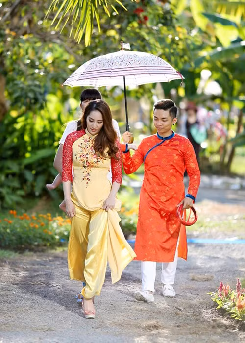 Dịp Tết Nguyên đán 2016, vợ chồng Phan Hiển - Khánh Thi cùng con trai đi chụp bộ ảnh áo dài. Ở hậu trường, anh không ngại che ô cho vợ để cô khỏi nắng. (Ảnh: Phununews)