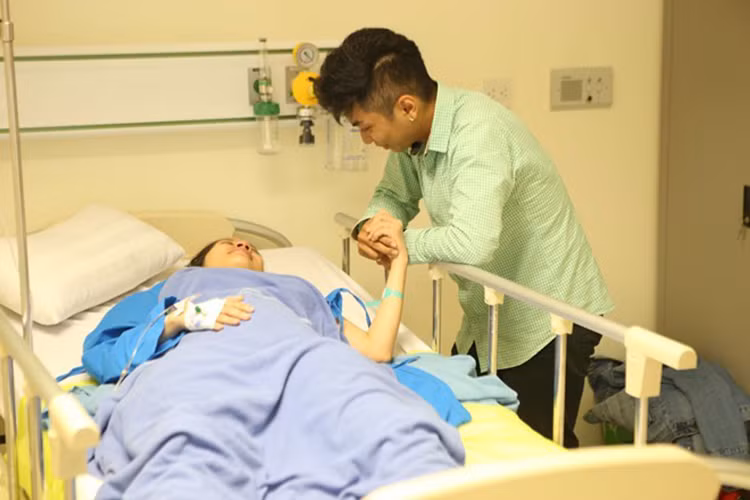 Phan Hiển ân cần nắm tay và động viên tinh thần Khánh Thi sau quá trình sinh nở đầy khó khăn. (Ảnh: Zing)