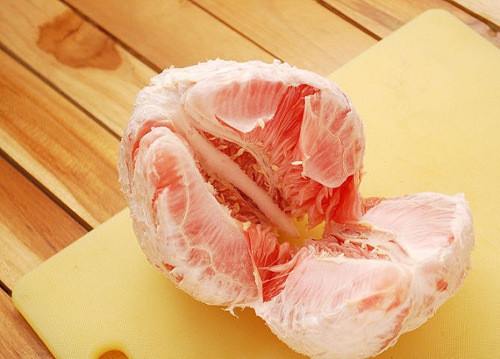 Bưởi nên chọn bưởi đào, chú ý chọn quả mỏng vỏ, căng mịn, nặng tay. Sau đó, gọt vỏ bưởi, tách múi. Để tránh thạch bưởi bị đắng nên loại bỏ phần xơ và cùi trắng của bưởi. Ảnh: Tiepthigiadinh.