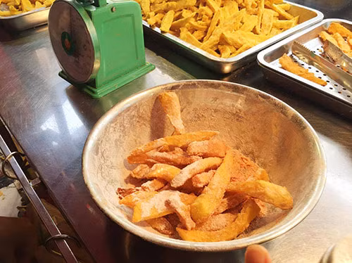 Bước 5: Cho khoai lang chiên vào hộp có nắp đậy, hoặc bát to, sau đó cho bột phô mai vào lắc đều là được. 