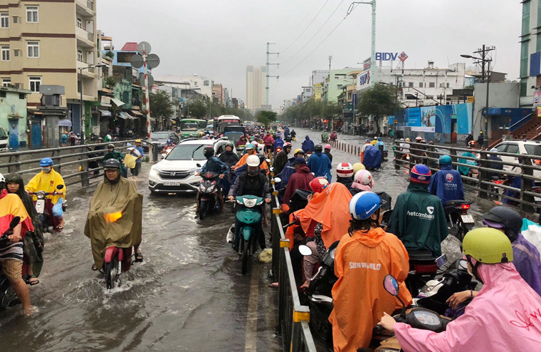 Nhiều người khi di chuyển qua cầu vượt Cây Gõ, thấy cảnh ngập nước đã dừng lại giữa cầu gây kẹt cứng trên cầu này.