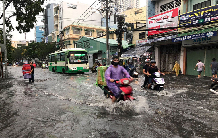 Người xe bì bỗm lội qua khu vực chìm sâu trong biển nước.