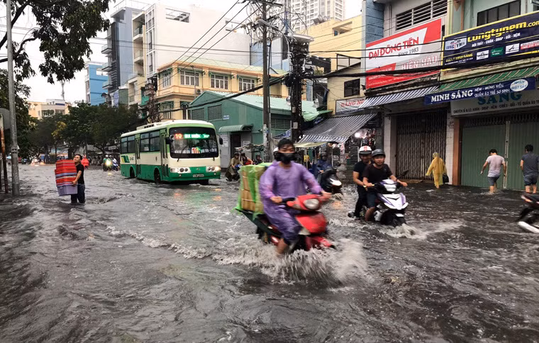 Người xe bì bỗm lội qua khu vực chìm sâu trong biển nước.