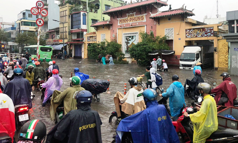 Để nhanh chóng thoát khỏi cảnh kẹt xe, ngập nước, nhiều người tranh thủ đi ngược chiều, leo lên dải phân cách mềm khiến giao thông thêm rối loạn.