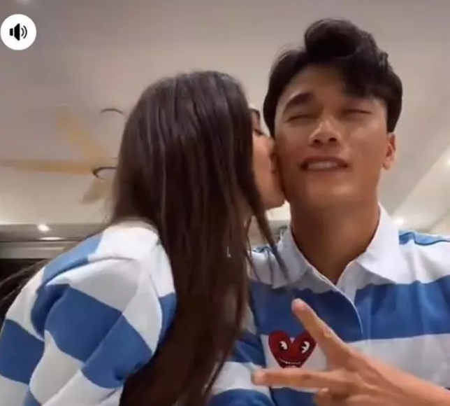 Trong clip, cặp đôi diện áo đôi, cùng tham gia một thử thách. Bạn gái Bùi Tiến Dũng bất ngờ quay sang thưởng cho một nụ hôn lên má.