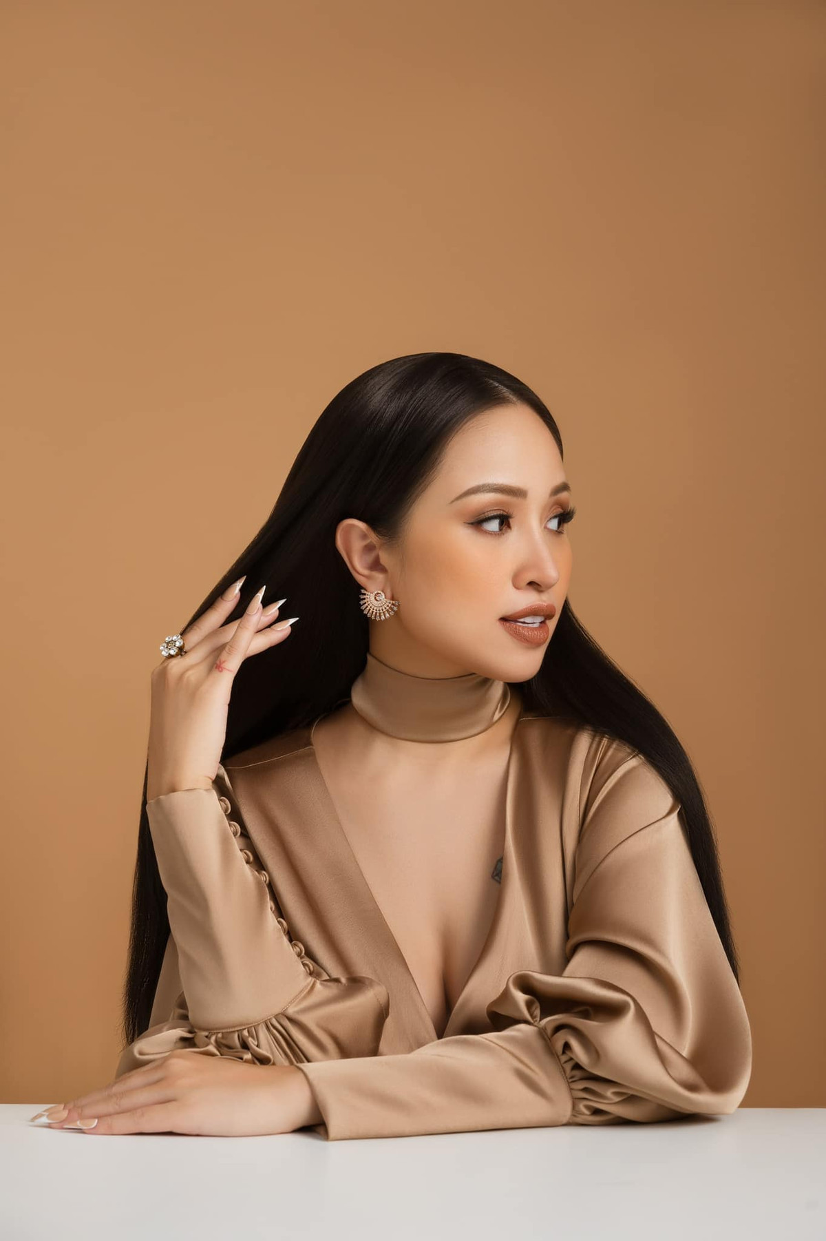 Trong bộ ảnh này, MC Vân Hugo diện đầm lụa tông nâu. Không cầu kỳ background chụp ảnh, cô chọn phông nâu cam đồng điệu với trang phục và tự tin thả dáng.