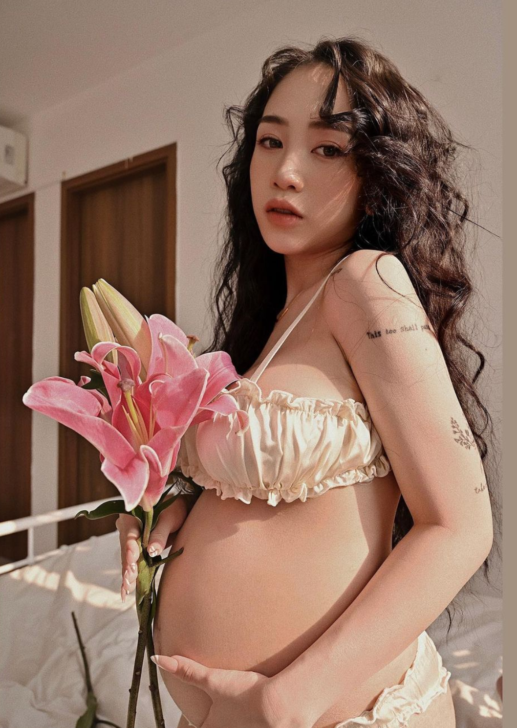 Khoảnh khắc ghi lại Joyce Phạm mặc bộ bikini màu vàng cát, thỏa sức tạo dáng trước ống kính cùng những cành hoa ly tươi xanh.