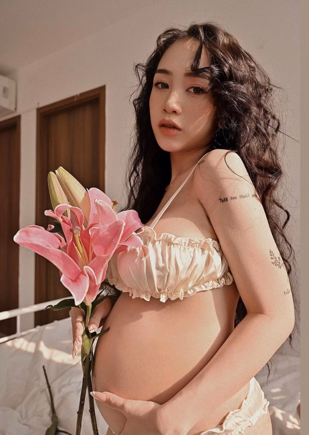 Khoảnh khắc ghi lại Joyce Phạm mặc bộ bikini màu vàng cát, thỏa sức tạo dáng trước ống kính cùng những cành hoa ly tươi xanh.