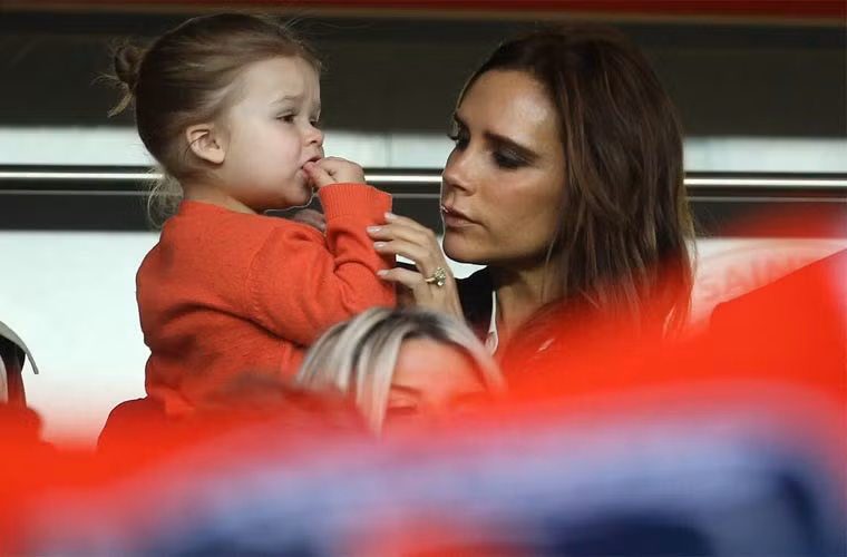 Khoảnh khắc tình cảm của Vic và công chúa út Harper trên khán đài một trận bóng năm 2013.