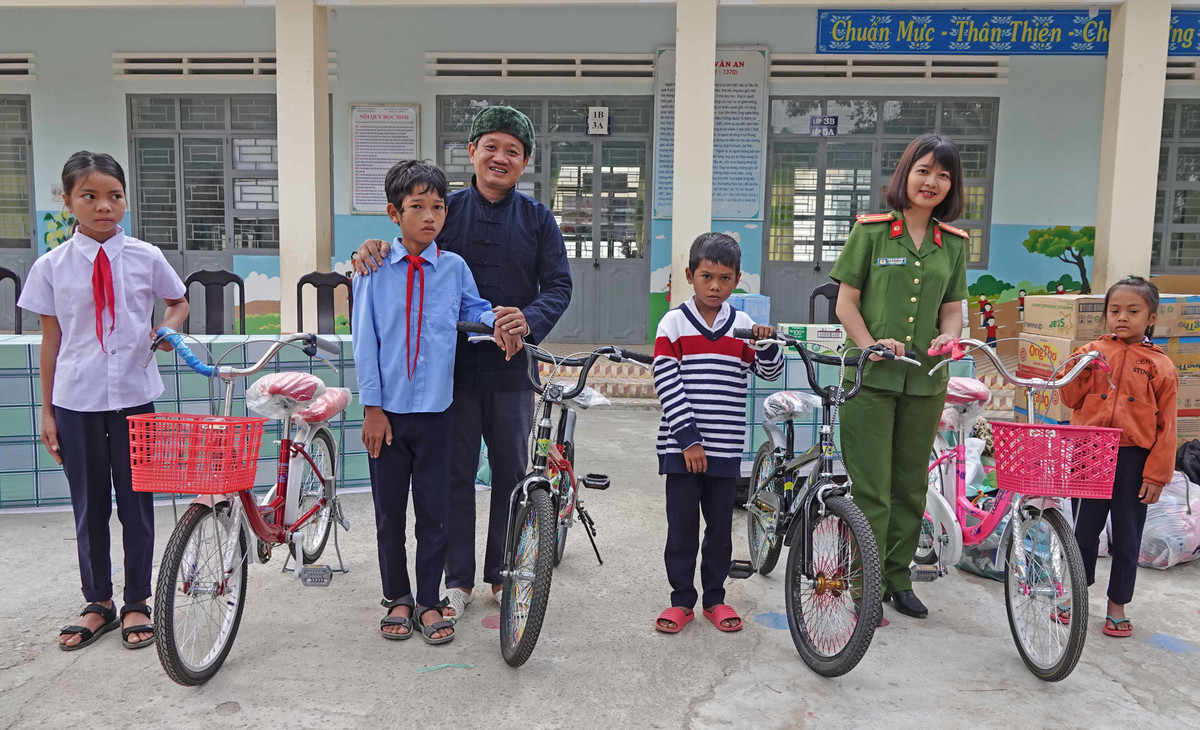 Bà Ksor H'bơ Khắp cùng ông Đoàn Ngọc Hải trong một lần tặng xe đạp cho học sinh nghèo tại Ayun Pa.