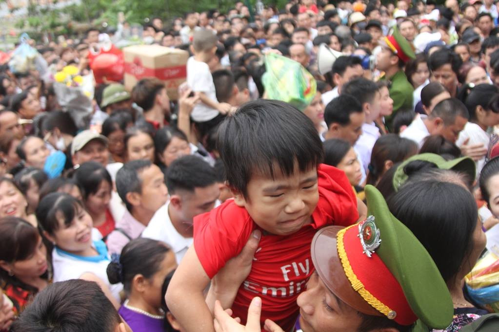 Một cháu bé được cán bộ công an bế lên.