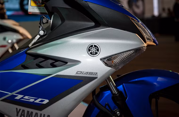 Phần yếm của Exciter 150 phảng phất những đường nét thiết kế trên những mẫu xe phân khối lớn mới của Yamaha như R15 hay R3. Yếm xe khá lớn và có những mũi nhọn tạo cho chiếc xe vẻ linh hoạt và khoẻ khắn. Nhìn từ bên hông cho cảm giác Exciter 150 lớn hơn so với bản cũ, nhưng kỳ thực thì nó nhẹ hơn Exciter 135 khoảng 1kg