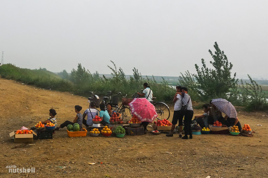 Người dân bán hàng trên một con đường đất ở khu vực nằm giữa Kaeju và Sariwon, Triều Tiên. Ảnh: EN.