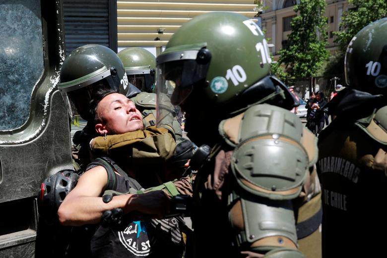 Lực lượng an ninh Chile bắt giữ một người biểu tình trên đường phố Santiago. 