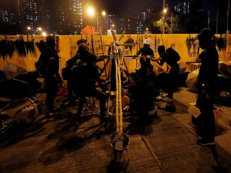 Người biểu tình thử máy bắn đá trên con đường dẫn tới trường Đại học Baptist Hong Kong ngày 13/11.