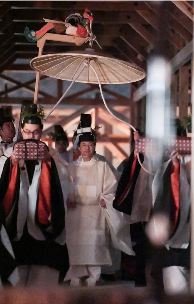 Nhật hoàng Naruhito trong trang phục áo choàng trắng đi đến Điện Suki của khu phức hợp Daijokyu để thực hiện nghi lễ Sukiden-Kyosen-no-gi tại Vườn Đông của Hoàng cung hôm 15/11.