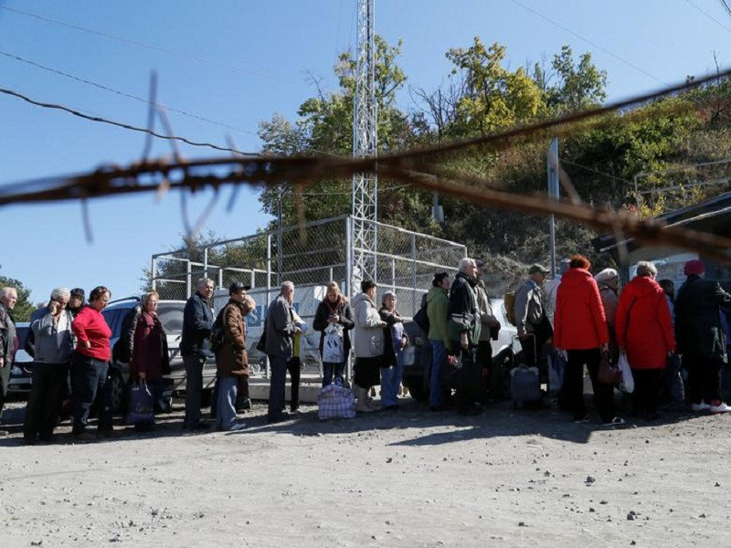 Người dân địa phương xếp hàng gần một cây cầu, vốn đã bị phá hủy trong cuộc xung đột ở miền đông Ukraine, tại khu định cư Stanytsia Luhanska ngày 25/9.