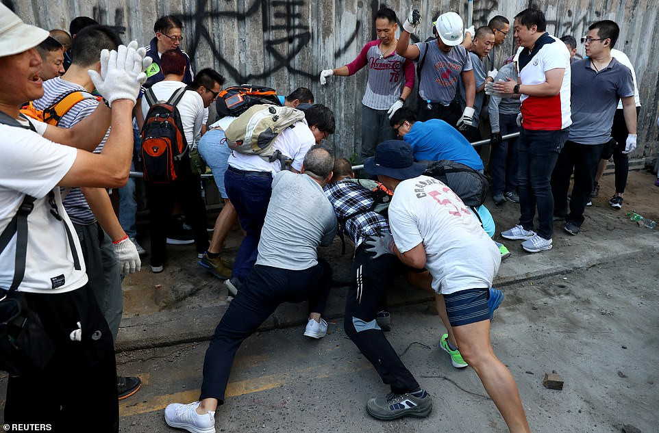 Được biết, đây cũng là lần đầu tiên trong hơn một năm qua doanh trại của Quân đội Trung Quốc tham gia vào hoạt động công ích ở đặc khu Hong Kong. Ảnh: Người dân đẩy một chướng ngại vật bên ngoài trường Đại học Hong Kong hôm 16/11. Ảnh: Reuters. 