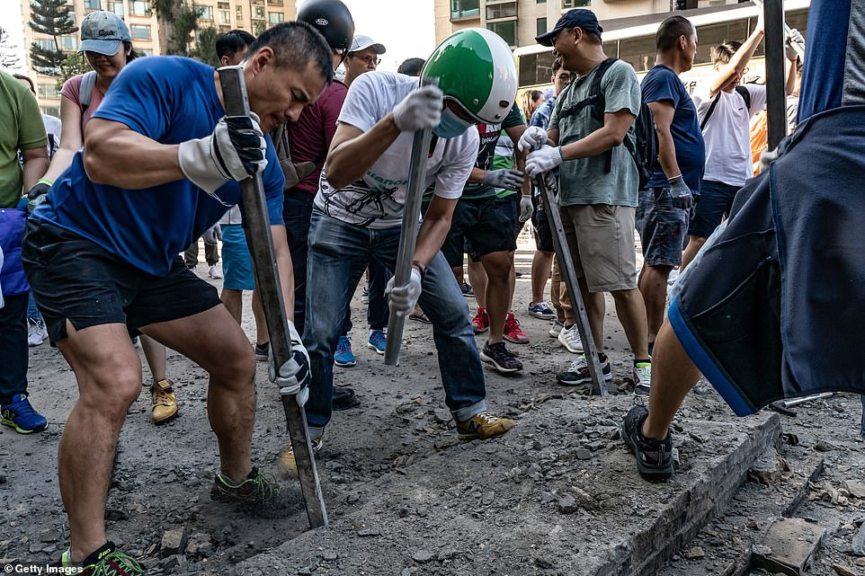 Lực lượng lính cứu hỏa, cảnh sát Hong Kong và người dân địa phương cũng tham gia công tác dọn dẹp đường phố Hong Kong trong ngày 16/11 vừa qua. Ngoài ra còn có một số người biểu tình. Ảnh: Getty. 