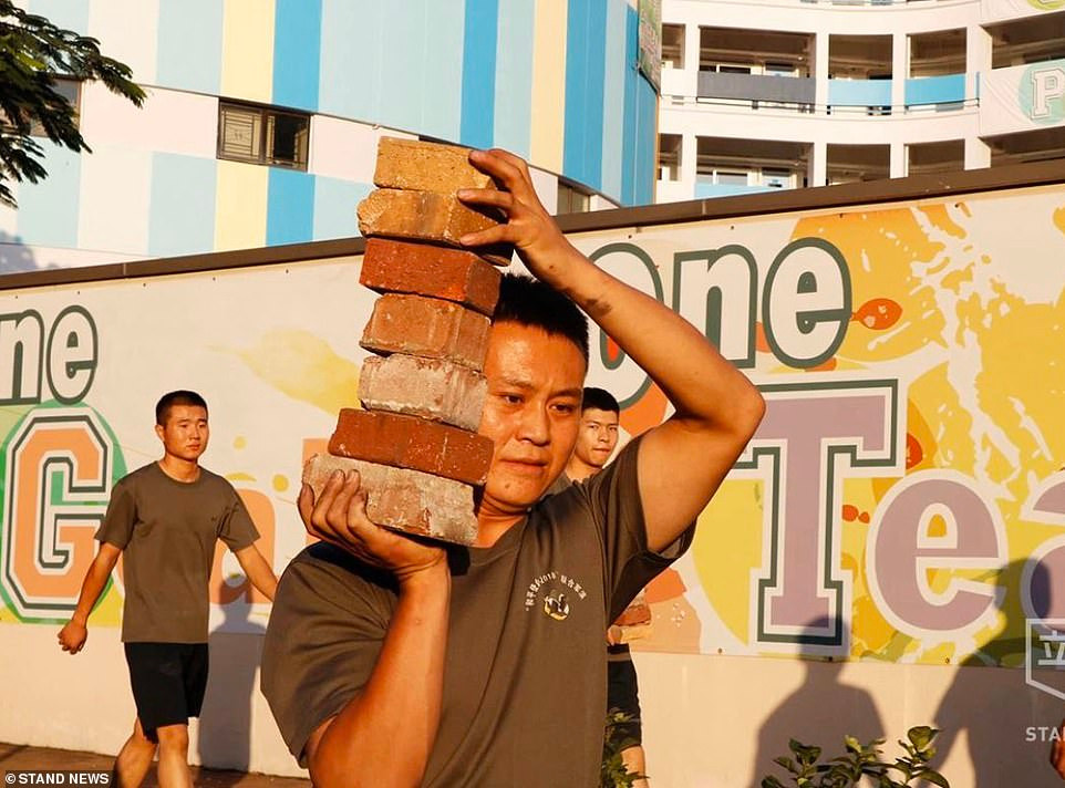 Một binh sĩ dọn dẹp gạch đá trên đường phố ở Hong Kong ngày 16/11. Ảnh: Stand News. 