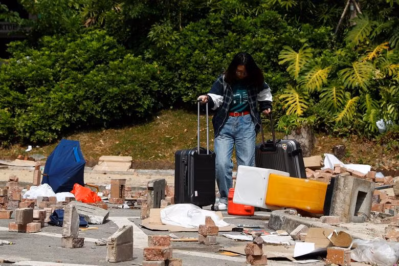 Hàng trăm sinh viên đại lục rời Hong Kong hôm 14/11 sau nhiều ngày bạo lực leo thang tại các trường đại học của đặc khu này. Ảnh: Một sinh viên đại lục mang theo hành lý rời khỏi Đại học Baptist Hong Kong ngày 14/11.