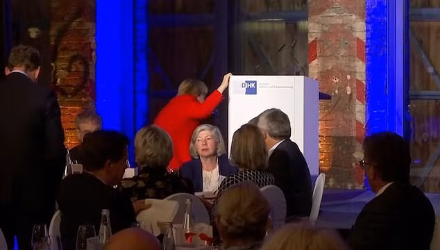 Nữ chính khách 65 tuổi sau đó giải thích rằng bà không để ý là có bậc thang để lên sân khấu và bị mất thăng bằng khi cố bước thẳng lên đó. Ảnh: Daily Mail.