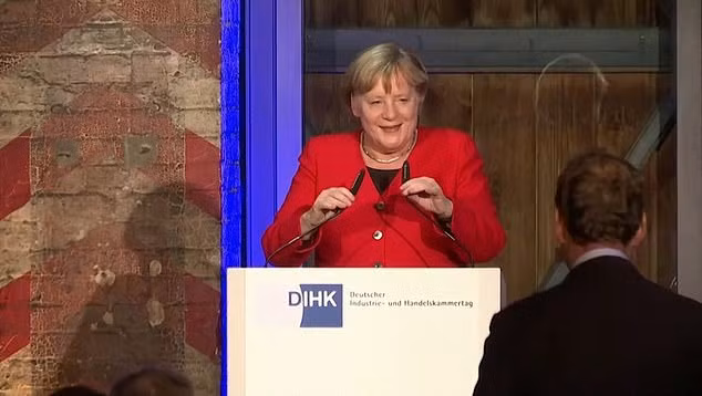 "Tôi không nhìn thấy cầu thang, tôi sẽ dùng thấy chúng lần sau", bà Merkel nói đùa sau khi đứng trên bục phát biểu. Ảnh: Daily Mail.