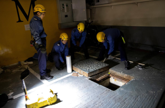 Các công nhân đóng nắp cống ngầm mà người biểu tình sử dụng để thoát ra ngoài.