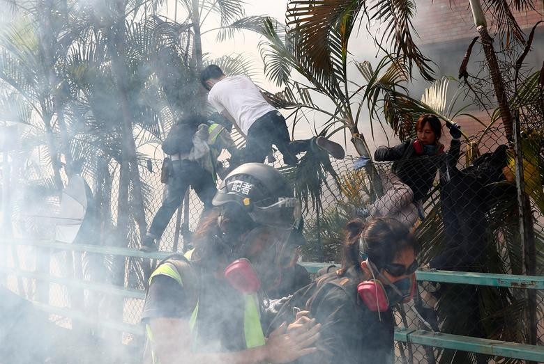 Nhóm người biểu tình bỏ chạy giữa làn khói hơi cay mù mịt.
