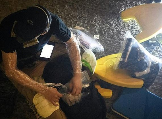 Một số người đã dùng túi bóng dày để bảo vệ tay và đầu khi phải bò vào các ống cống dưới lòng đất. Ảnh: Daily Mail.