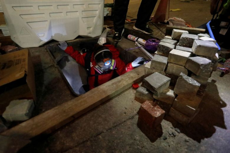 Khi cảnh sát siết chặt vòng vây, người biểu tình bên trong trường đại học PolyU đã cố thoát ra ngoài bằng cách đi xuống các đường cống ngầm dưới lòng đất. Ảnh: Reuters.