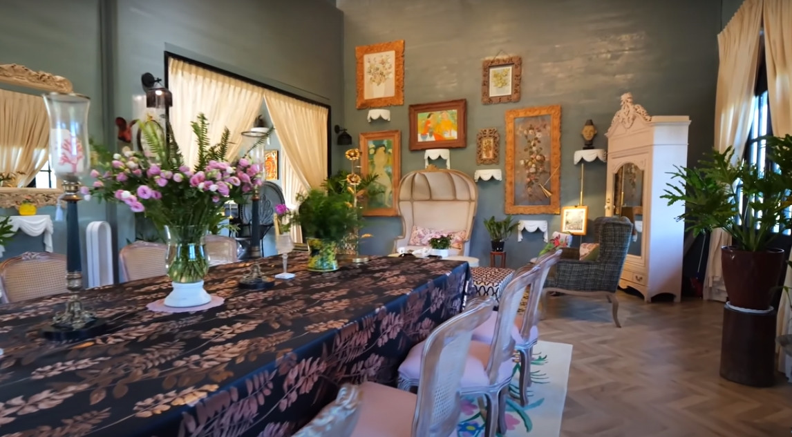 Bàn ăn dài được tô điểm bằng những lọ hoa tươi.