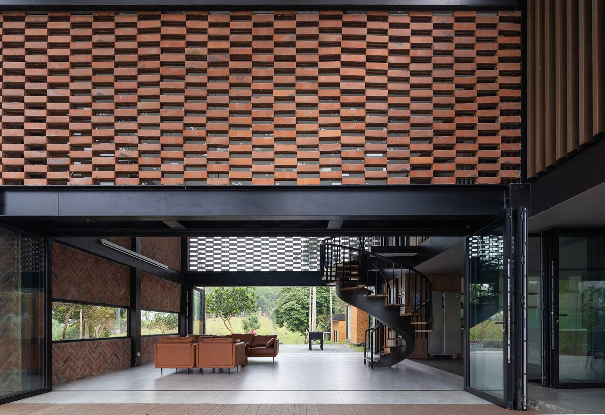 Để che chắn ánh nắng mặt trời phía Tây mà không ảnh hưởng đến tầm nhìn toàn cảnh, kiến trúc sư đưa ra giải pháp sáng tạo liên quan đến hệ thống rèm bằng gạch treo.