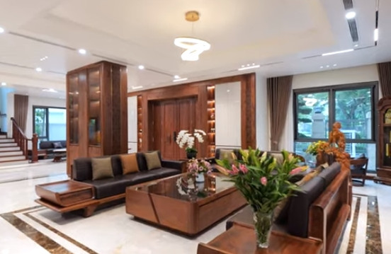 Phòng khách rộng nổi bật với bộ sofa lớn bằng gỗ óc chó kết hợp da.