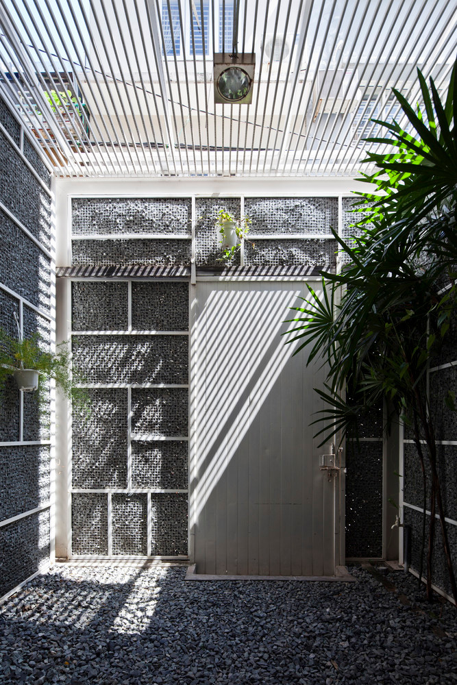 Khoảng không trước nhà phủ một lớp đá răm. Đây cũng là khu vực để xe của gia đình.