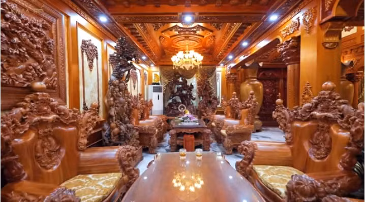 Phòng khách nổi bật với bộ bàn ghế gỗ gồm 8 chiếc ghế lớn.