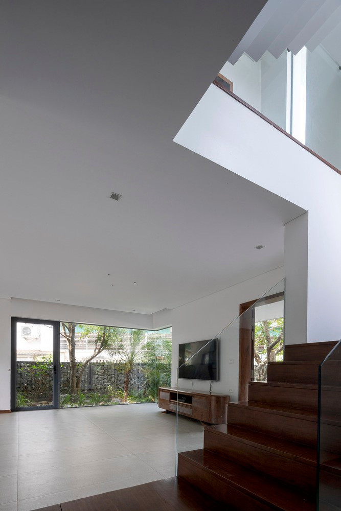 Trên khu đất hình thang, cùng với nhu cầu của gia chủ, nhóm thiết kế đã tính toán bố trí các công năng chính như khu sinh hoạt, phòng ăn và không gian bếp tầng 1. Phòng ngủ tầng 2 và 3 xung quanh là các công năng phụ trợ như thang máy, nhà vệ sinh...