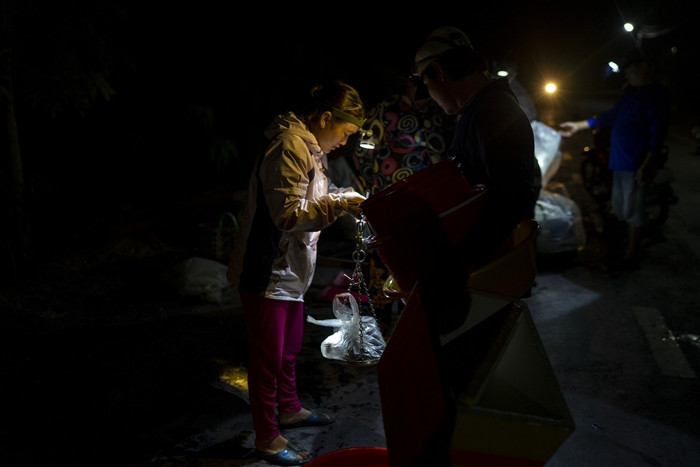 Một điểm đặc biệt nữa tại chợ Tha La là người bán và người đi chợ thường tự chuẩn bị đèn pin để soi hàng. Ảnh: PNS