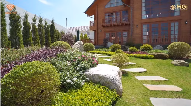 Khu vườn xanh mướt với thảm cỏ và các loại cây cảnh, hoa tươi.