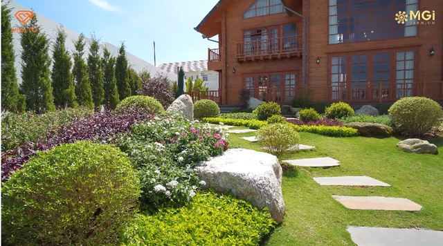 Khu vườn xanh mướt với thảm cỏ và các loại cây cảnh, hoa tươi.