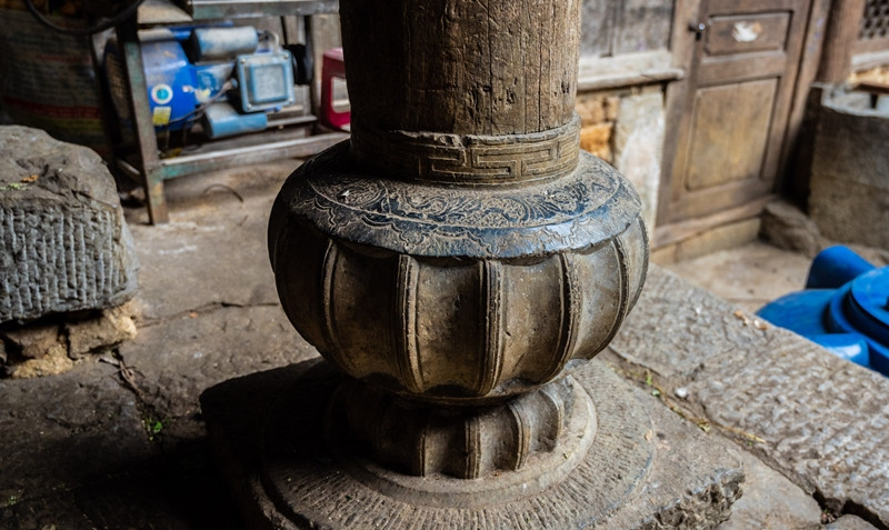 Bên trong nhà, họa tiết hoa anh túc xuất hiện khắp nơi, từ trên cột kèo gỗ đến chân cột nhà bằng đá. Ảnh: Vietnamnet