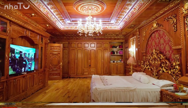 Tuân theo ngôn ngữ thiết kế chung của căn biệt thự, phòng ngủ trên tầng 2 sử dụng toàn bộ gỗ gõ đỏ.