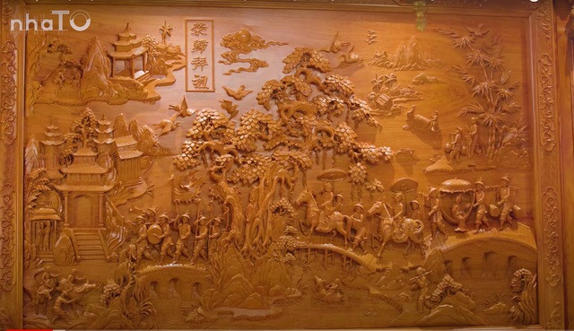 Điểm nhấn của căn phòng là bức tranh Vinh quy bái tổ, được chạm khắc trực tiếp vào tường gỗ.