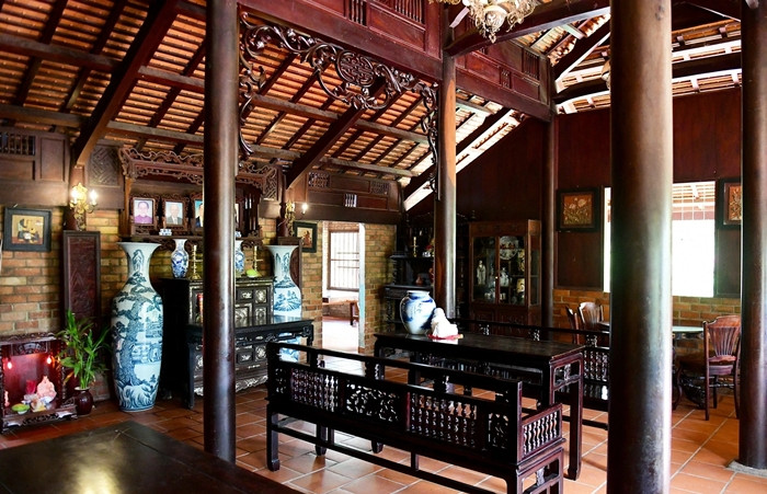 Trong khuôn viên khu nhà, căn nhà chính đã gần 100 năm tuổi. Căn nhà được gia chủ mua vào năm 2002 ở tỉnh Bình Dương, có giá 25 cây vàng rồi mang về lắp đặt, sau đó ông mua thêm 2 xác nhà khác để bổ sung các chi tiết bị hư hỏng. Ảnh: Dân trí