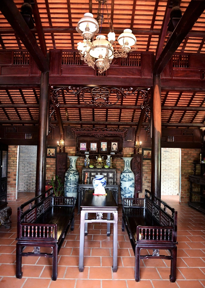 Ngôi nhà dựng bằng 54 cột gỗ gõ mật. Gian chính có diện tích 60 m2, với đầy đủ nội thất đặc trưng như bộ trường kỷ, phản... đều có tuổi đời khoảng 50 năm. Ảnh: Dân trí