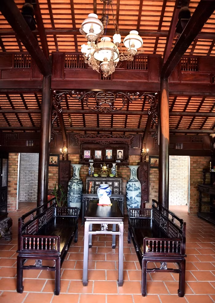 Ngôi nhà dựng bằng 54 cột gỗ gõ mật. Gian chính có diện tích 60 m2, với đầy đủ nội thất đặc trưng như bộ trường kỷ, phản... đều có tuổi đời khoảng 50 năm. Ảnh: Dân trí