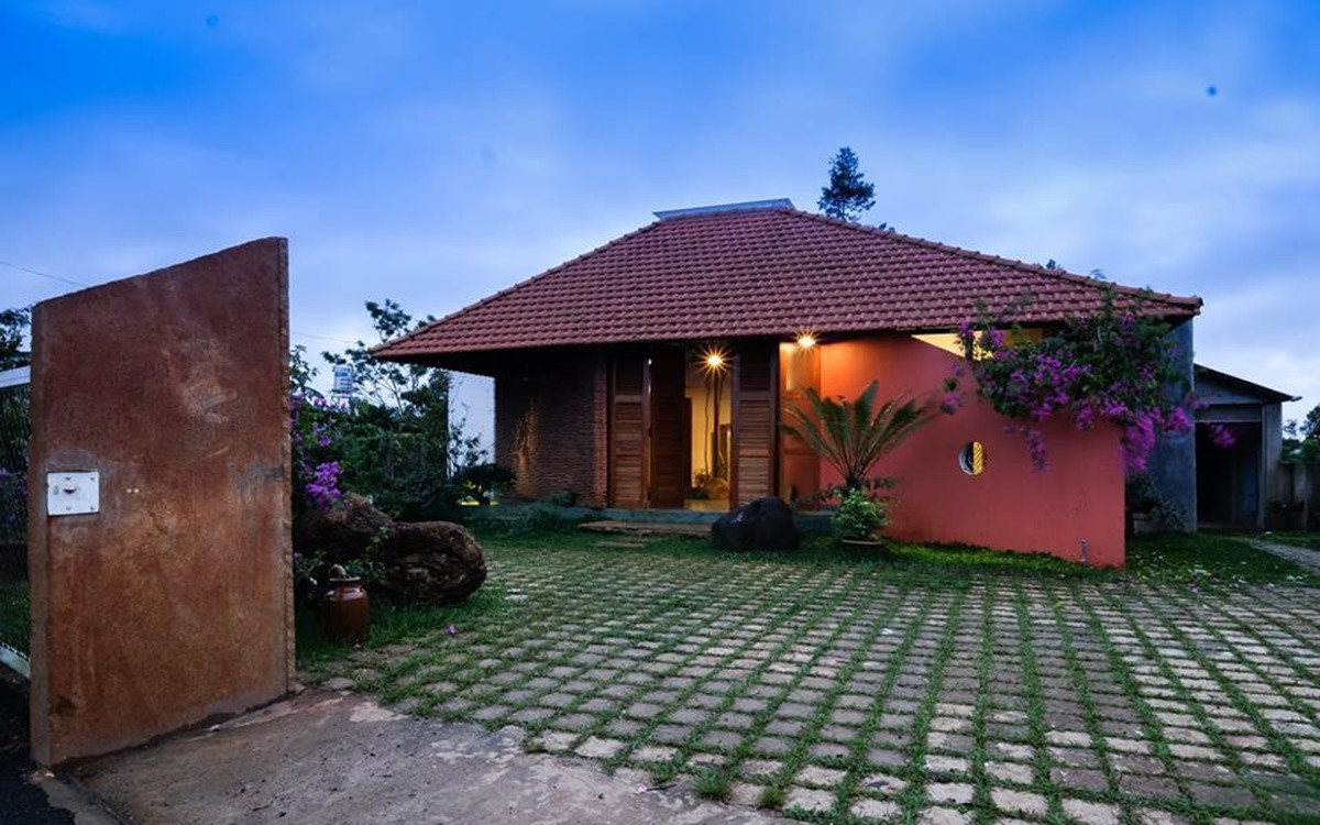 Nhìn bên ngoài, căn nhà nổi bật với khoảng sân rộng, mái ngói đỏ và những cánh cửa gỗ gấp đặc trưng ở vùng nông thôn.