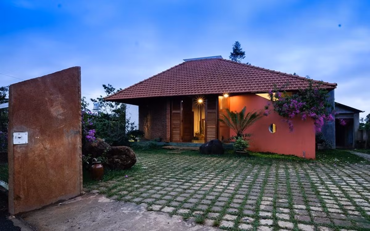 Nhìn bên ngoài, căn nhà nổi bật với khoảng sân rộng, mái ngói đỏ và những cánh cửa gỗ gấp đặc trưng ở vùng nông thôn.