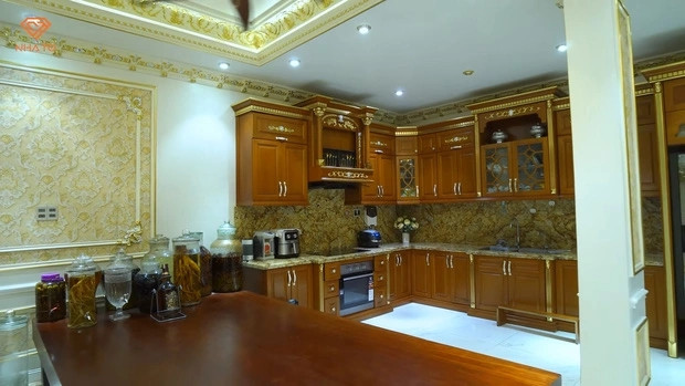 Khu vực bếp được làm từ gỗ gõ đỏ, mặt bếp ốp đá marble nhập khẩu.